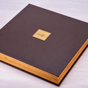 Caderno de madeira com capa de couro marrom e marca personalizada em folha de ouro.