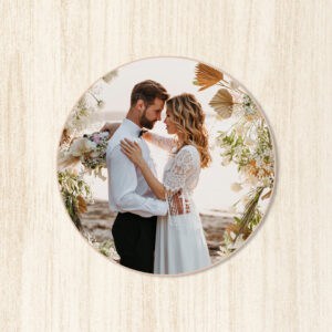 Casal de casamento à beira-mar com decoração floral, romantismo e amor no pôr do sol.