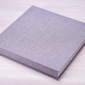 Livro de capa dura cinza em fundo de madeira clara.