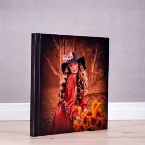 Menina com chapéu de bruxa e buquê de girassóis, cenário outonal, arte fotográfica.